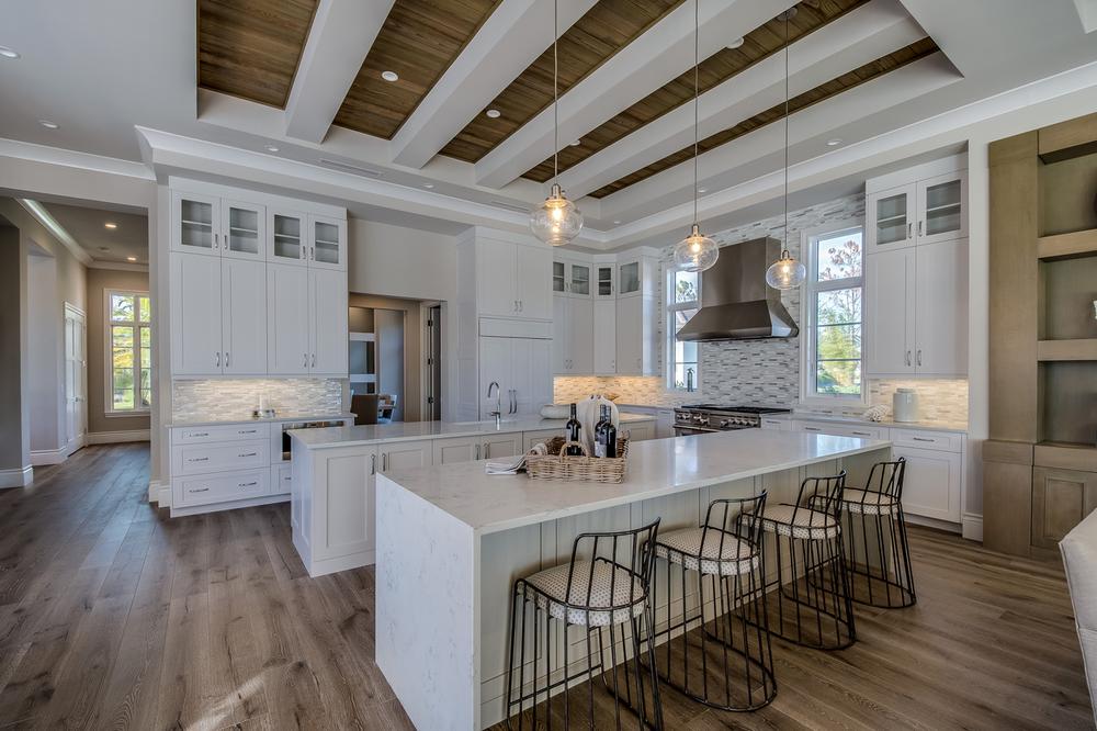 White cabinets, hardwood floor and coffered ceiling